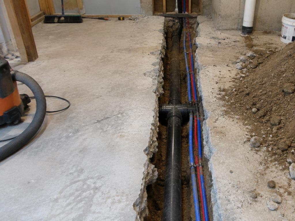 Trench cut in a basement concrete floor for new plumbing lines